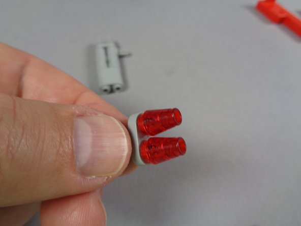 As shown in the second photo for this step, re-attach the second red transparent cone over the second LED light.