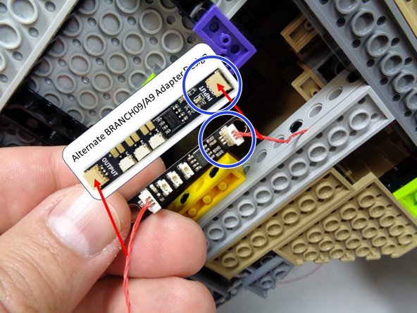 As shown in the first photo, take the second BRANCH09 adapter board from Bag 10 and connect the red control wire (coming from the first BRANCH09 adapter board that you connected earlier) to the large plug on the second BRANCH09 closest to the small plugs.