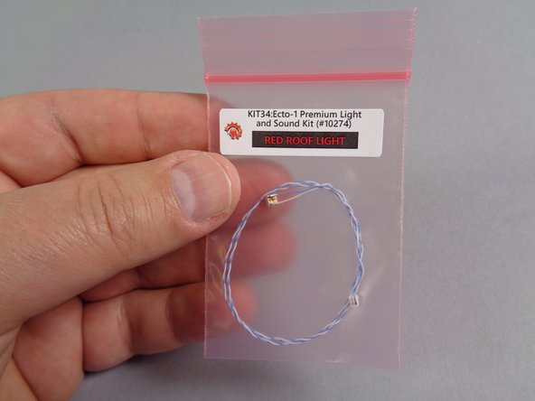 As shown in the first photo for this step, remove the small pink bag labeled &quot;Red Roof Light&quot; from the &quot;Roof Parts&quot; bag.