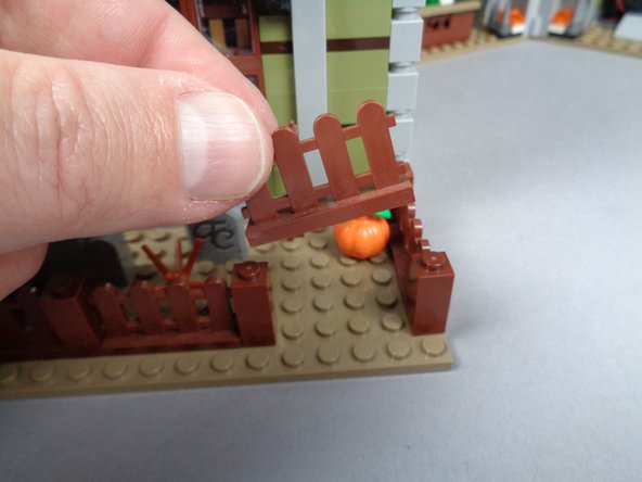 As shown in the photos for this step, remove the right front fence section and attach one of the slopes with LED light on top so the light is facing toward the house.