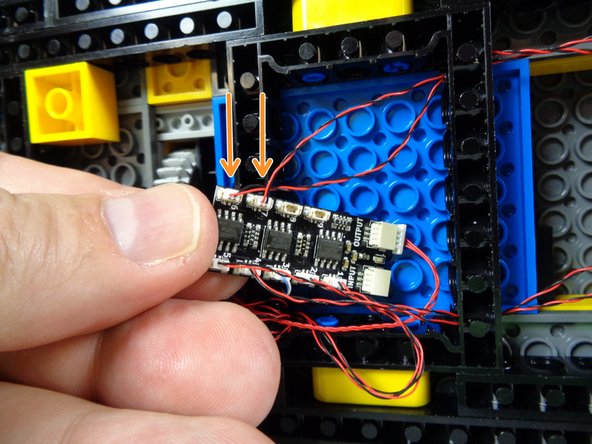 As shown by the two orange arrows in the third photo for this step, connect the two tail light wires to plugs #6 and #7 on the BRANCH09X adapter.