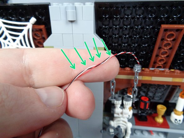 As shown by the green arrows in the first and second photos for this step, carefully un-twist a section of the control wire where it will pass  through the chimney.