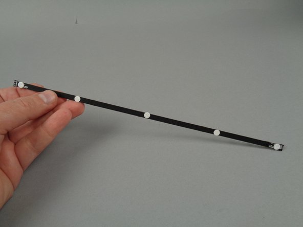 As shown in the photos for this step, attach sticky dots to the backs of the eight 17-LED strips and the eight 20-LED strips.