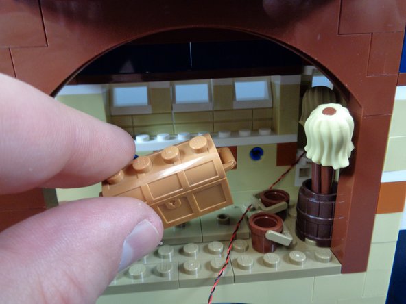 As shown in the photos for this step, remove the treasure chest from the magic room and run the light wire behind it, along the back wall.