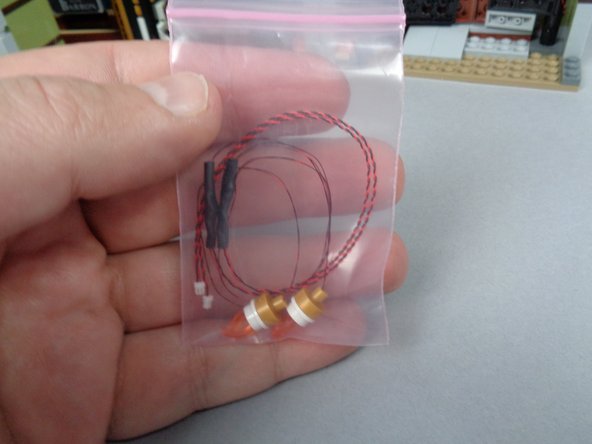 As shown in the first photo for this step, your BOX #1 contains a small bag with two pre-lit wall sconces in it.  You will use these to replace the two un-lit sconces in your mansion.