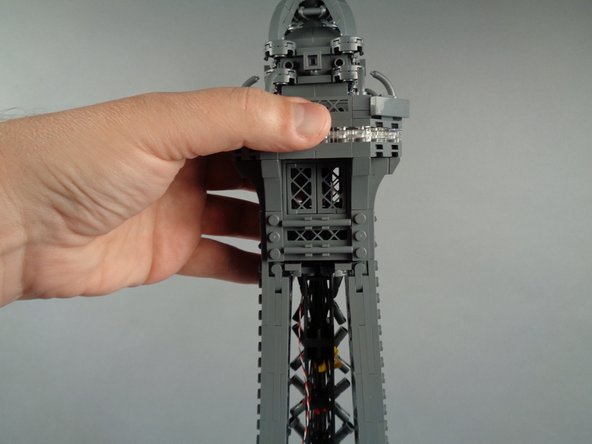 Pull the wire down into the center of the top tower section as you finish re-attaching the broadcast tower section.