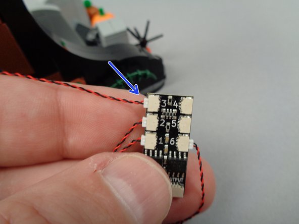 As shown by the arrow in the third photo for this step, connect the first yellow LED light to plug #3 on the BRANCH06X driver board.