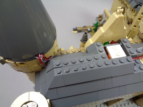 Continue re-attaching roof pieces as shown in the photos for this step, being careful not to pinch any wires on top of studs.