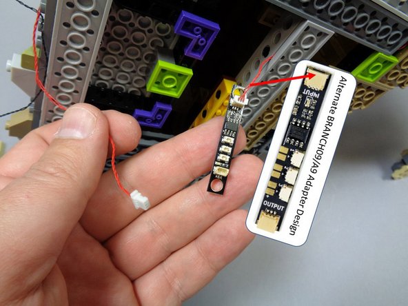 Gently turn the castle on its side once again, and disconnect the red wire from the side of the BRANCH09 adapter board closest to the small plugs.