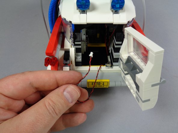 As shown in the third photo,  you should be able to pull the heavy-duty connecting cable up into the rear of your Ecto-1.