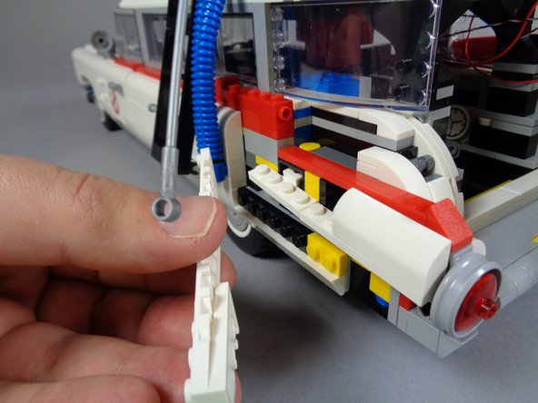 As shown in the photos for this step, disconnect the hose on the left side of the vehicle and remove the same parts of the vehicle frame as you did for the right side.