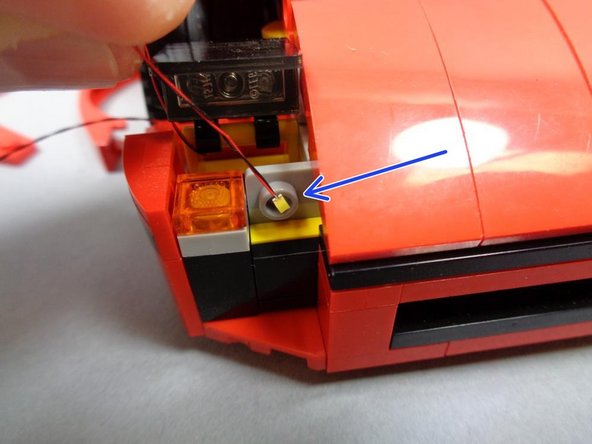 As shown by the blue square, tilt up the headlight cover so you can feed the LED wire through the yellow bracket.