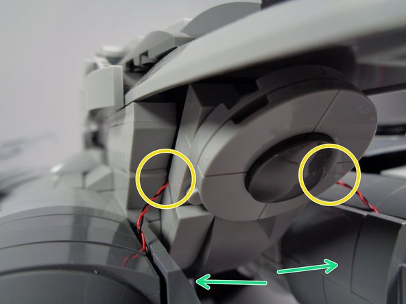 There is a gap in the bricks, shown by the orange circle in the first photo.  Pass each light wire through this opening, as shown by the green arrows.