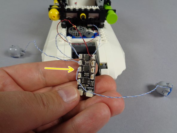 As shown by the orange arrow in the first photo for this step, connect one of the blue roof lights to plug #4 on the BRANCH09X adapter board.