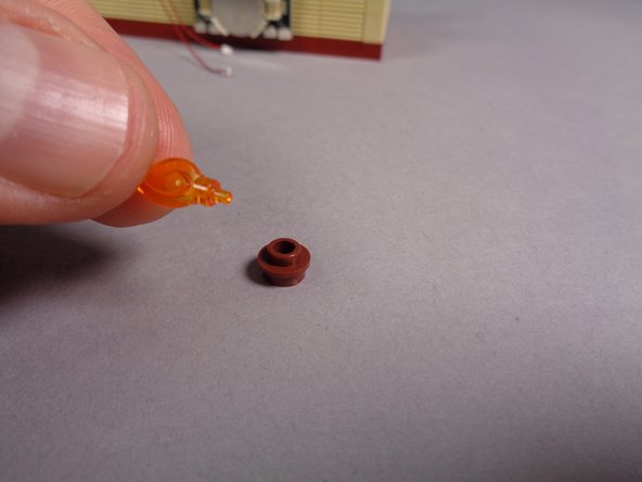 As shown in the second photo, remove the transparent orange flame from the round brown 1x1 plate.