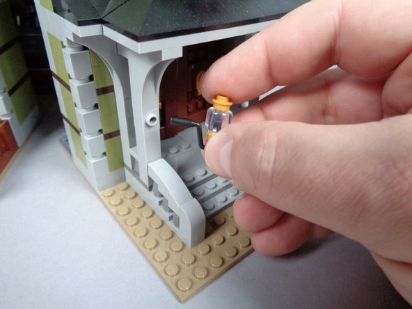 As shown in the third photo for this step, remove the clear and top gold parts from both porch lights.