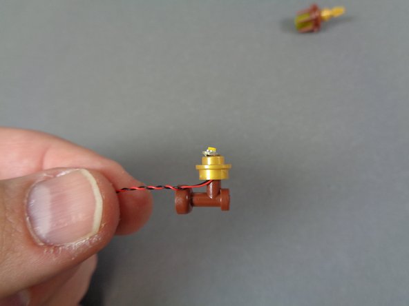 As shown in the first photo, carefully re-insert the brown part into the bottom of the round gold plate.