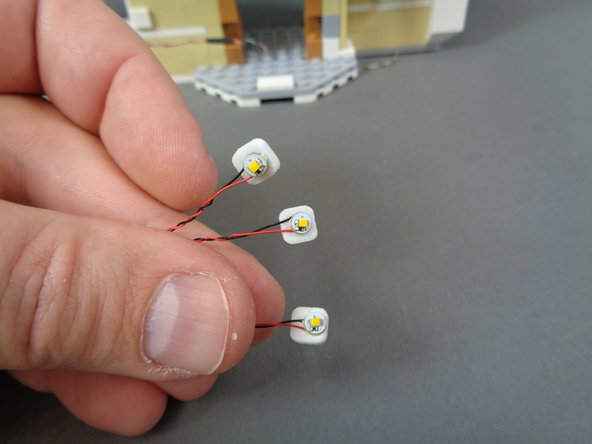 As shown in the second photo, attach one small sticky square to the back of each warm white Pico LED light.