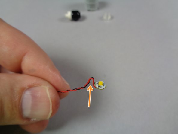 As shown by the orange arrow in the first photo, carefully bend the light wire up, then down, to create a small &quot;bump&quot; in the wire.  This is needed to hold the light correctly in place.