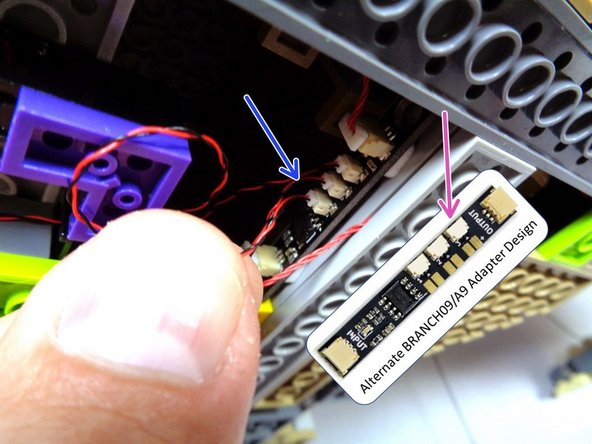 If your BRANCH09 adapter board has top-facing connectors, connect the cauldron light power wire to the last open plug on the BRANCH09 adapter as shown by the blue arrow in the second photo.  All five plugs on the BRANCH09 adapter board should now be full.