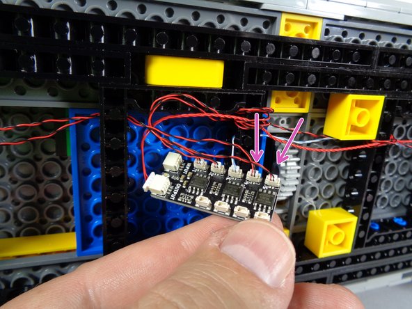 As shown by the two pink arrows in the second photo for this step, connect the two tail lights to plugs #4 and #5 on the BRANCH09X adapter.