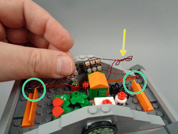 As shown by the yellow arrow in the photo for this step, coil up any excess light wires so all wires will fit neatly in the attic area.