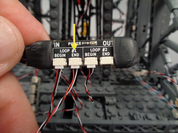 As shown by the yellow arrow in the photo for this step, connect the control cable to the "END" plug in the "LOOP #1" section of the inter-level connecting board.