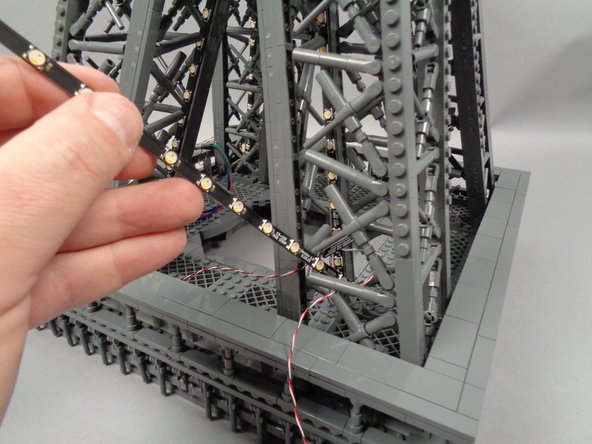 As shown in the first photo for this step, pass the light strip connected to plug #2 on the adapter board into the center of the pillar.