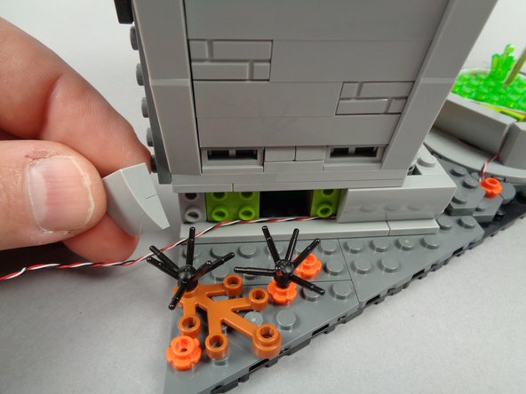 As shown in the second photo for this step, remove the rear base slope piece from the side of the town hall.