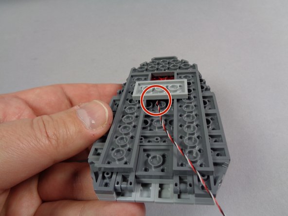 As shown in the first photo for this step, carefully begin re-attaching the parts that hold the eye in place.