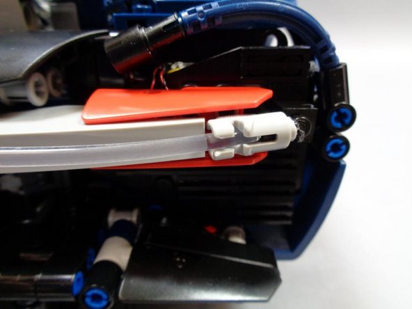 Carefully insert the long, clear fiber optic tube into the holes in the two &quot;blaster&quot; assemblies  (one on each side of the rear of the Bugatti).