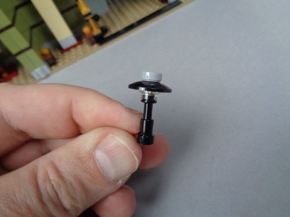 As shown in the first photo, remove the bottom lamp assembly from the bag inside BOX #2, and make sure the LED light on top is pressed flat as shown by the orange arrow.