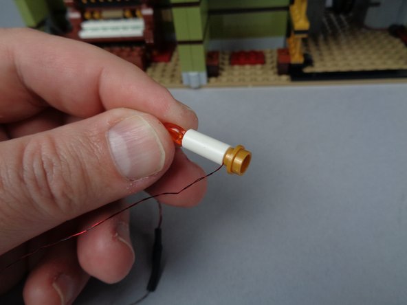 As shown in the third photo for this step, carefully re-attach the gold candle base plate.