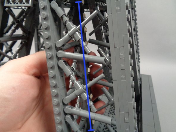 Now you can finally attach the light strip to the inside rear of the pillar.  As shown in the photo for this step, press with two fingers to make sure the light strip adheres firmly to the tower frame.