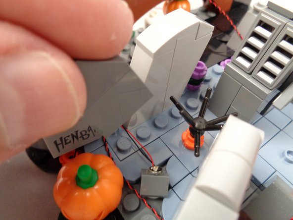 As shown in the second photo for this step, remove the 1x2 tombstone behind the LED Light and pass the light wires between the studs under the tombstone.