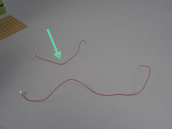 Your BOX #2 has two warm white Pico LED lights, one with a short wire and one with a longer wire.  As shown by the green arrow in the first photo for this step, you will be using the light with the shorter wire now.