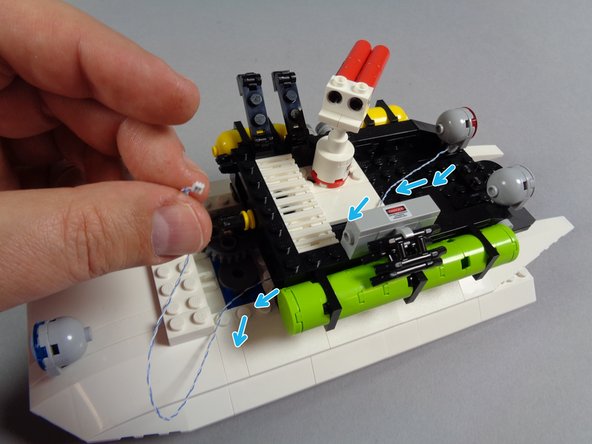 As shown in the second photo for this step, pull the light wire under the black plate and out into the rear area of the roof.