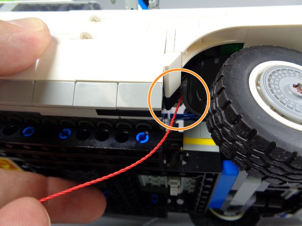 As shown by the orange circle in the third photo for this step, make sure the wire passes behind the wheel well and does not touch or come close to the tire.