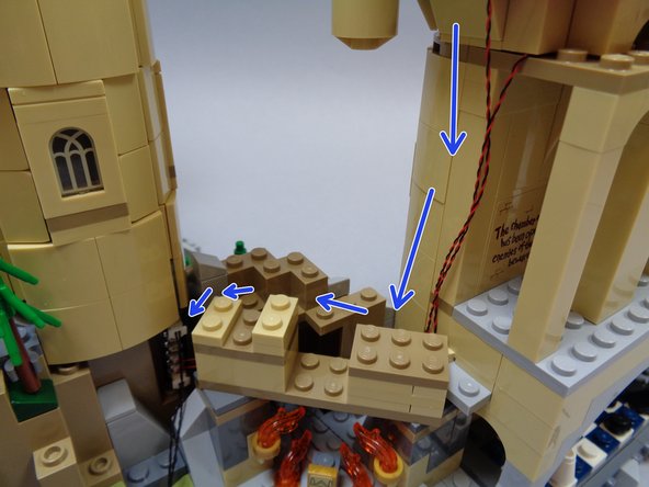 Run the two light wires (from Umbridge's Office and the Defense Against the Dark Arts classroom) down along the side of the castle as shown by the blue arrows in the second photo.