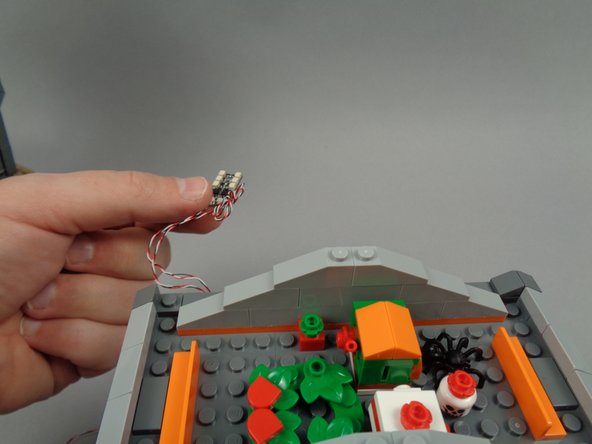 As shown in the second photo for this step, remove the BRANCH06X driver board from the attic, and leave it hanging loosely from the back of the town hall (held in place by the curtain pieces).