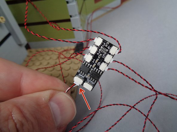 As shown by the red arrow in the second photo for this step, connect one end of the 3-wire cable to the INPUT plug on the second BRANCH06X adapter board.