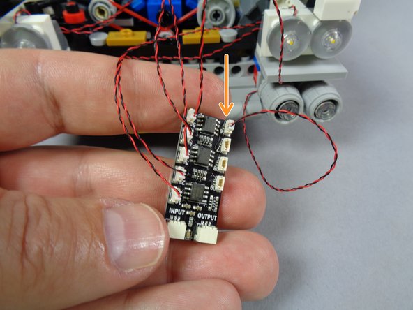 As shown by the orange arrow in the third photo for this step, connect the second lower headlight to plug #6 on the BRANCH09X adapter.