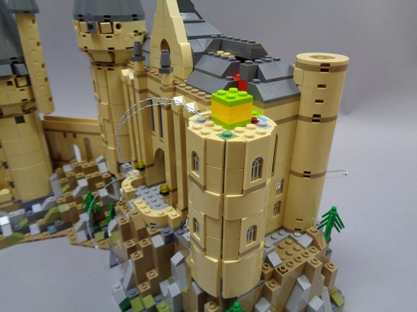 Now you will remove parts in the side of the tower to allow you to mount three warm white lights (inside Bag 10) in three of the tower windows.