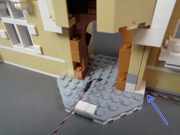 The second photo shows the wire after the black connector end has been passed through the hole in the floor.