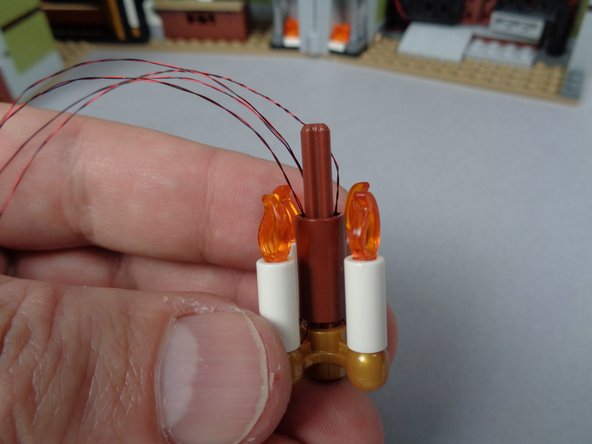 The end result should look like the third photo for this step: all four candles mounted with their wires passing up and out the top of the center chandelier support axle.