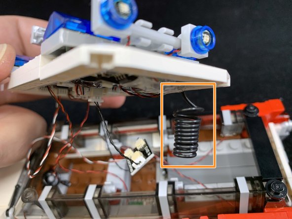 As shown by the orange square in the first photo, make sure the thick black coiled wire is pointing downward before re-attaching the roof.  This is the antenna wire for the remote control.