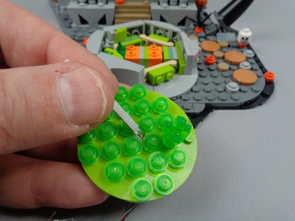 As shown in the second photo for this step, pull the light strip through the hole from the top until its end (where the wire connects) is flush with the hole opening.