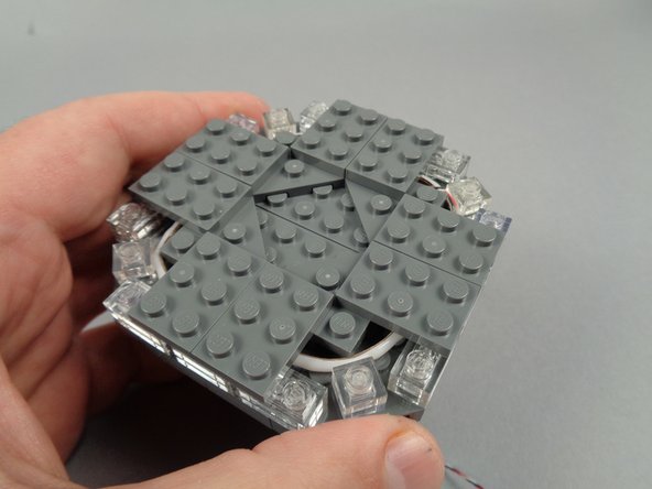 As shown in the photos for this step, continue re-assembling the broadcast tower with the eight 2x3 LEGO plates you removed earlier.