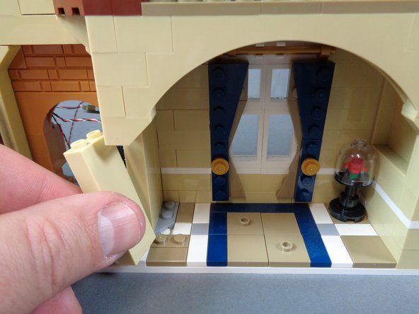 As shown in the first photo for this step, carefully remove the tan pillar behind the candelabra table.