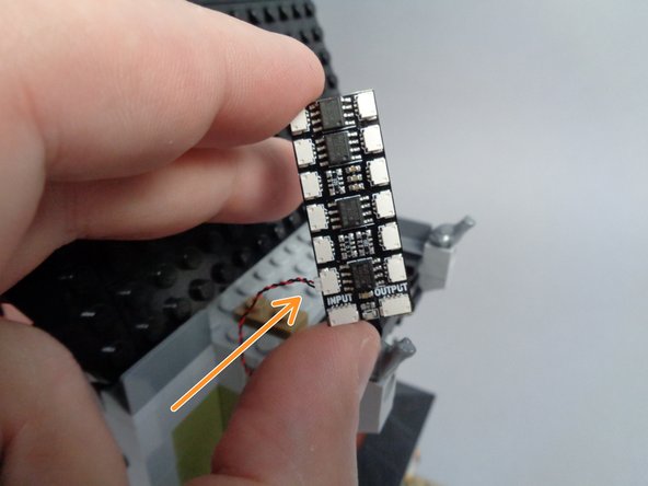 As shown by the orange arrow in the second photo for this step, connect the fireplace light wire to plug #1 on the BRANCH12X adapter board.